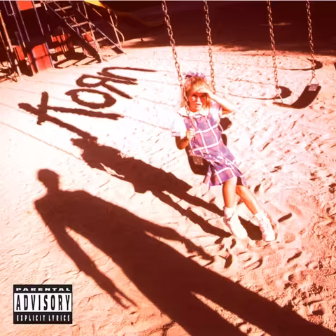 Front cover of Korn (1994), Stephen Stickler photograph of a small blonde girl in a school uniform sat on a swing, looking up at the threatening shadow of a man on the sand in front of her.