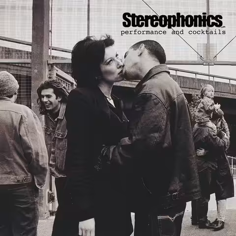 Front cover of Stereophonics' Performance and Cocktails (1999), photographed by Scarlet Page under the Westway in west London: a young couple kiss on a football pitch, the woman's hands hanging at her sides.