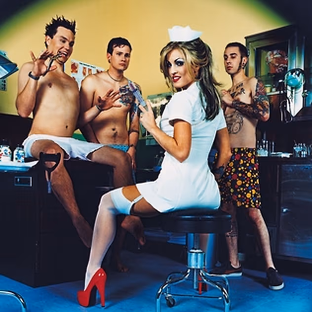 Back cover of Enema of the State: the three members of Blink-182, mostly shirtless, posed around Janine Lindemulder in a white nurse dress, white stockings and red heels, seated on a stool in a clinical exam room