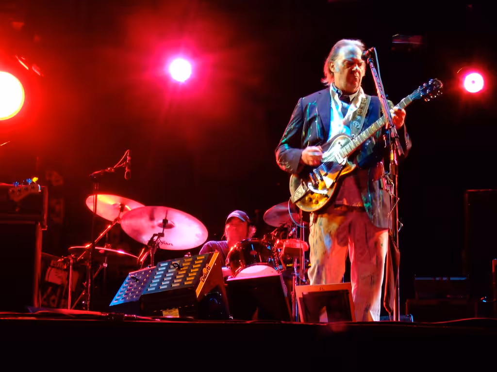 Neil Young playing an electric guitar and singing on stage at the Bospop festival in the Netherlands in 2008.