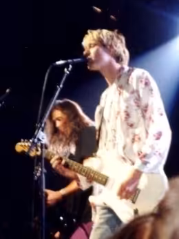 Kurt Cobain and Krist Novoselic of Nirvana performing on stage in 1992, Cobain at the microphone with a guitar.