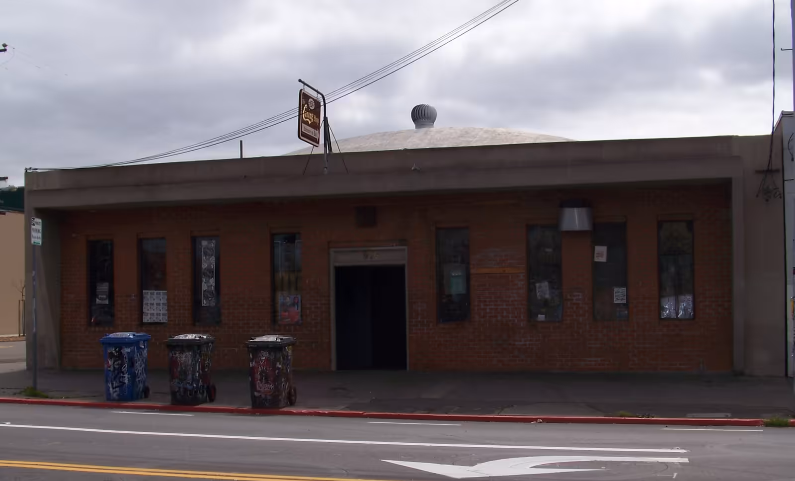 The plain exterior of the 924 Gilman Street club in Berkeley, its walls covered in stickers and flyers.