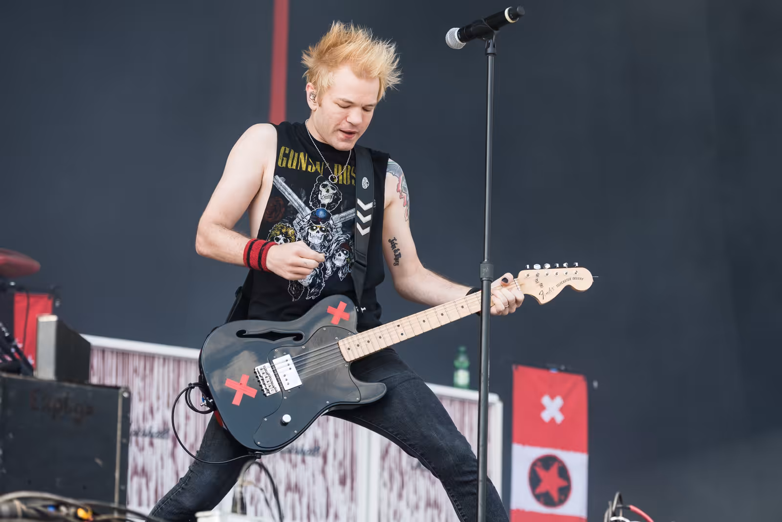 Sum 41 frontman Deryck Whibley singing and playing guitar on stage in 2017.